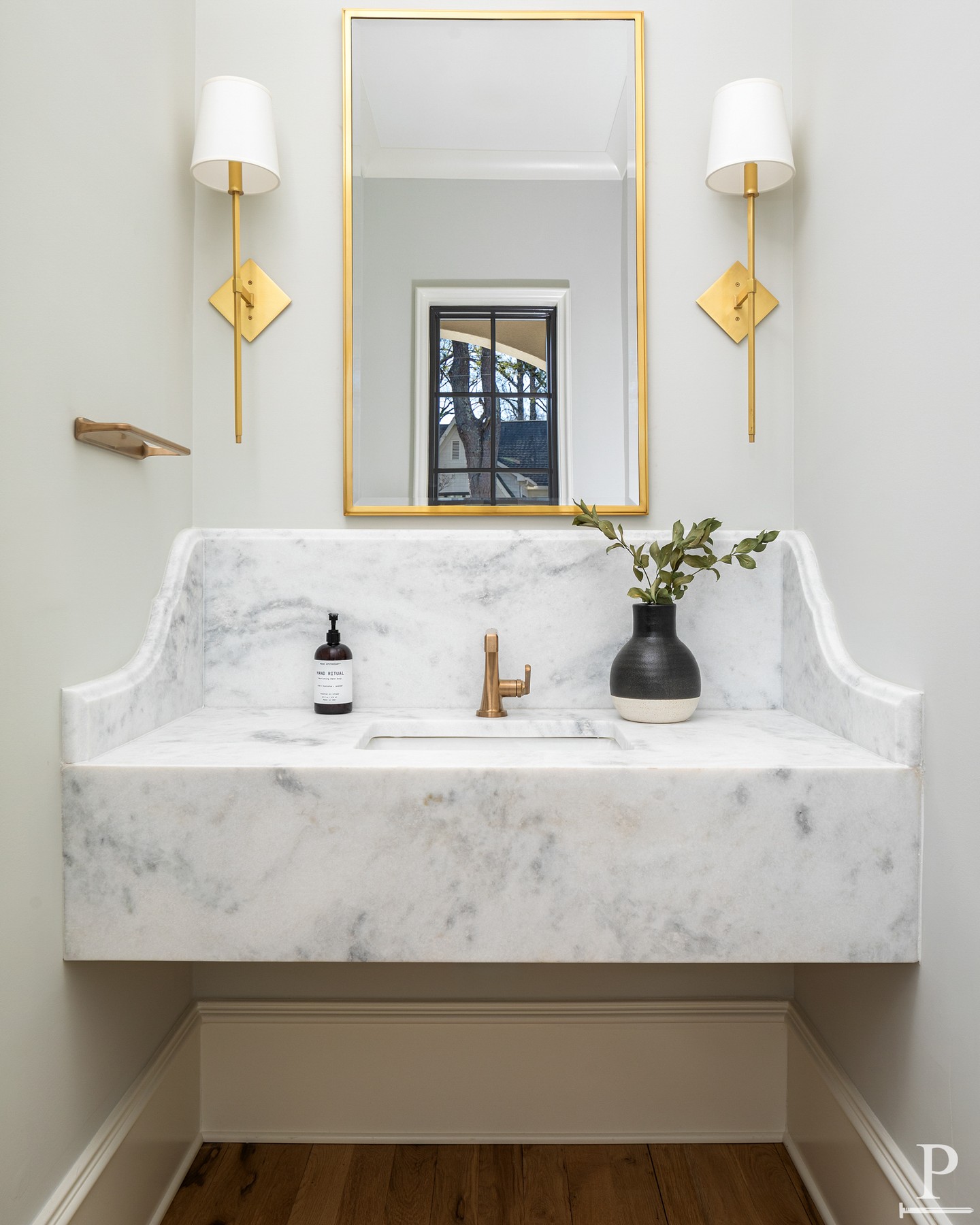 A powder bath built around one idea: let the marble do the talking.
The sink floats off the wall as a single carved slab, rolled edges, its own built-in backsplash. No hardware competing for attention, no extra layers. Just stone, brass, and enough restraint to let the room breathe.
This is what happens when you design a small space like it matters. 🫧