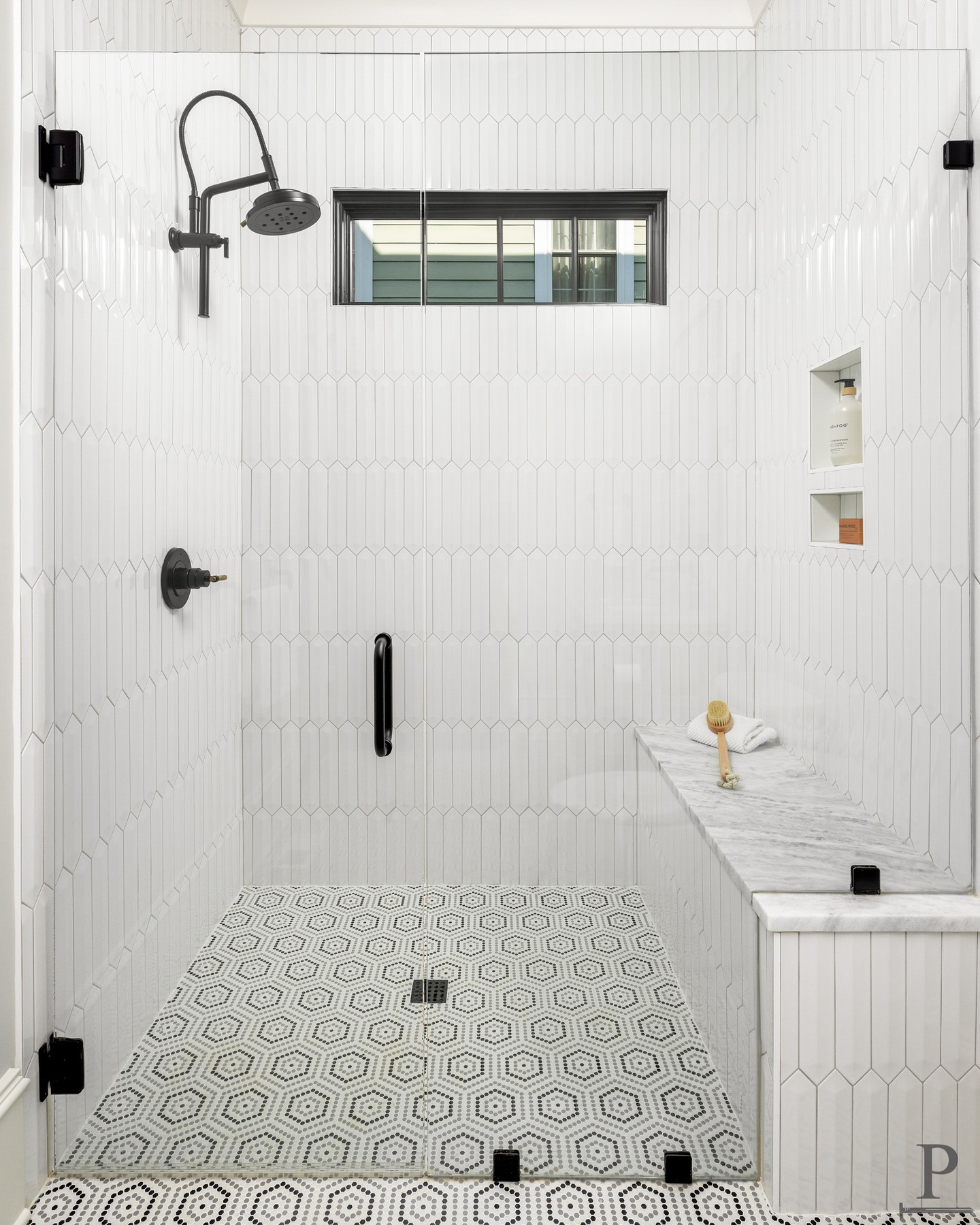 Elongated picket tile, a marble bench, and a black-framed window for natural light. This shower was designed with detail at every turn. 🖤