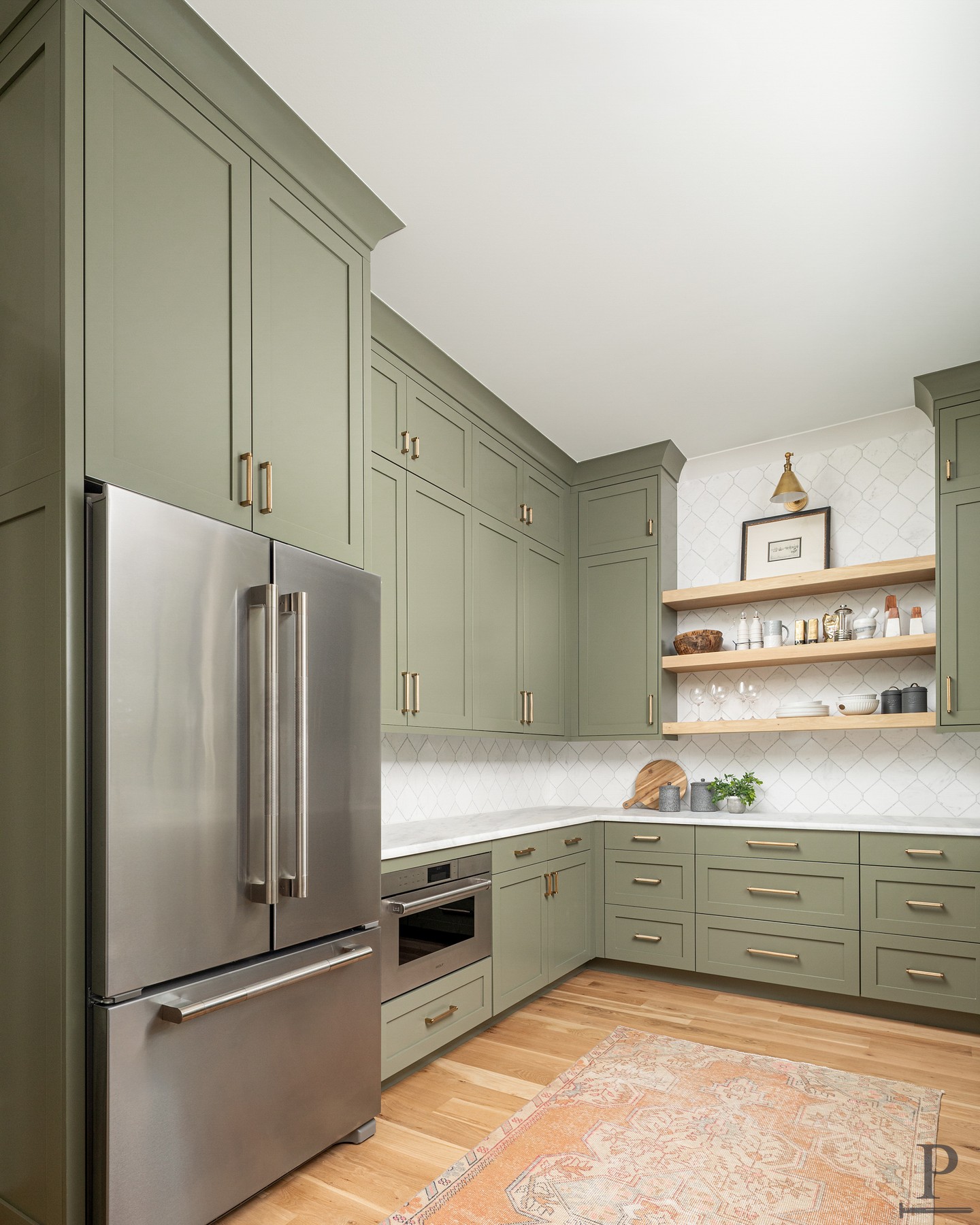 A scullery built to handle the real work.
Olive green cabinetry, a diamond tile backsplash, and a built-in wine fridge keep everything organized and out of sight from the main kitchen.