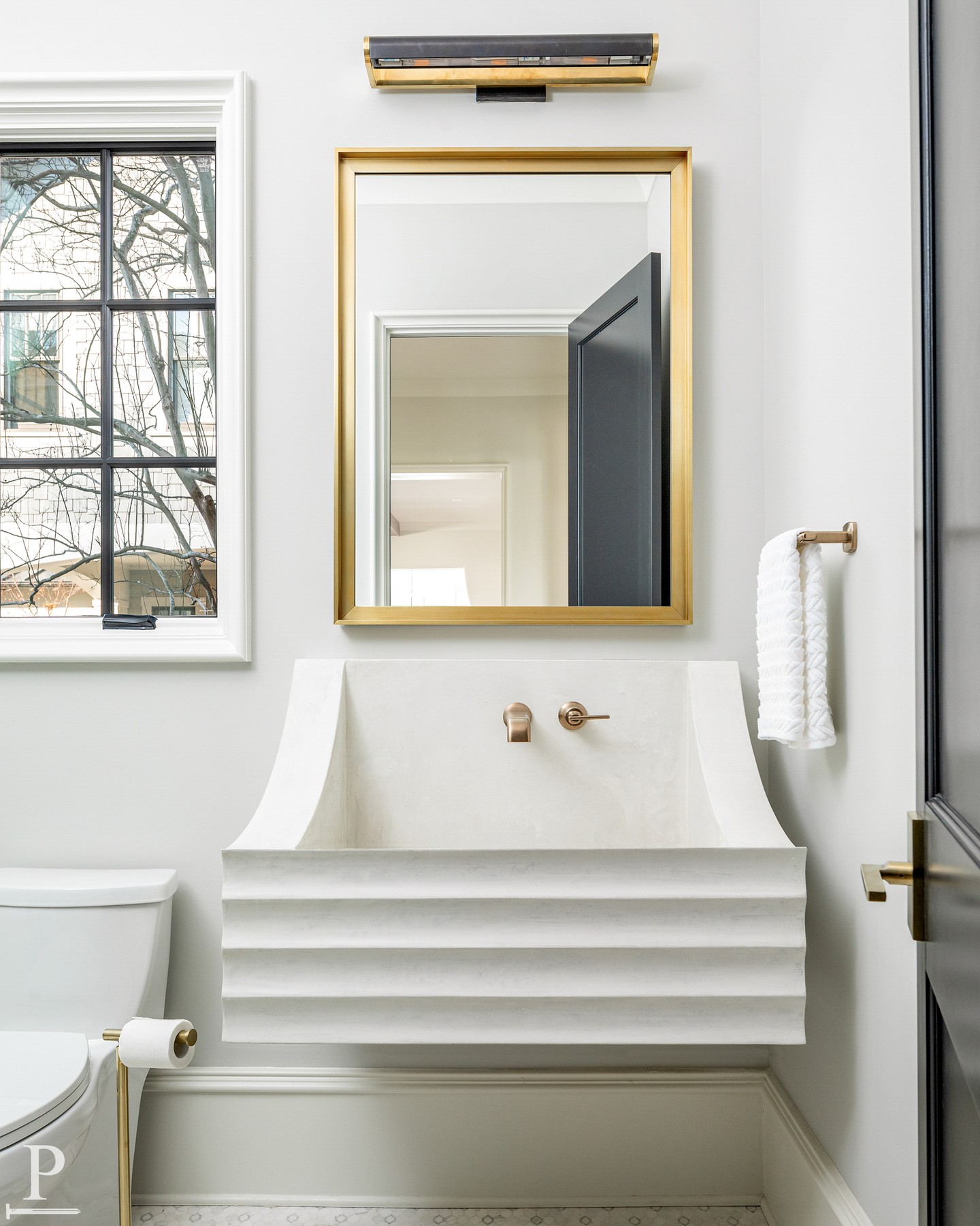 Sometimes the smallest room makes the biggest statement. This sculptural floating sink, paired with a brass framed mirror and warm hardware, proves that even a powder room deserves the details. ✨