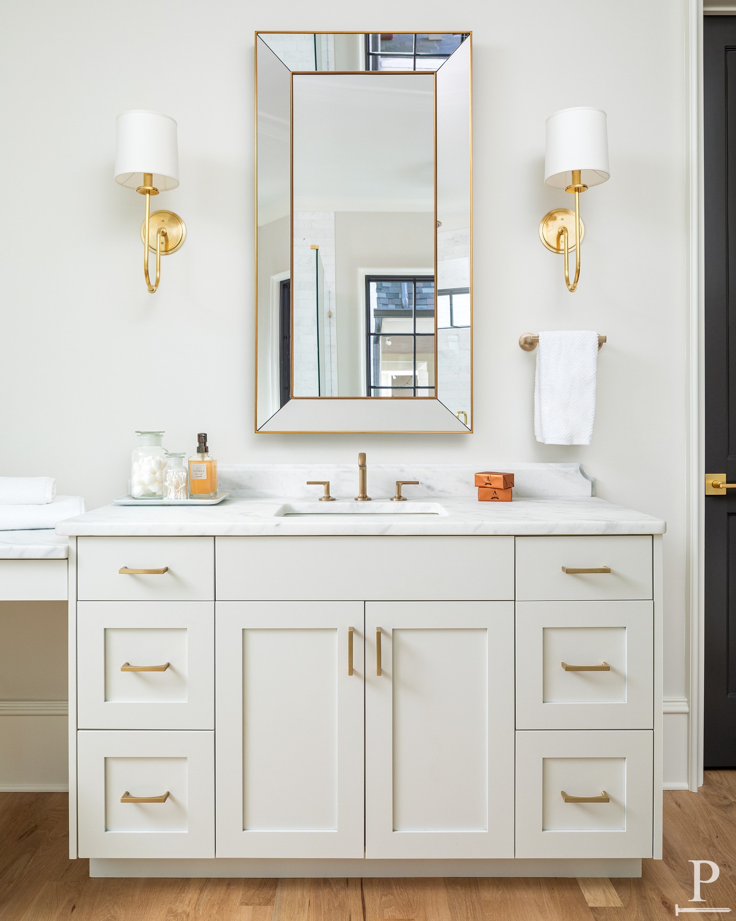 Soft white cabinetry, marble counters, and brass fixtures that catch the light just right. This primary bath is proof that timeless never goes out of style. 🫧
