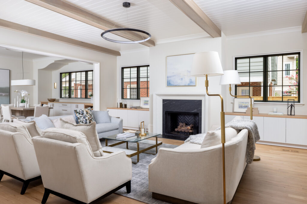 Bright living room with sliding glass doors leading to the backyard, white oak floors, and exposed ceiling beams.