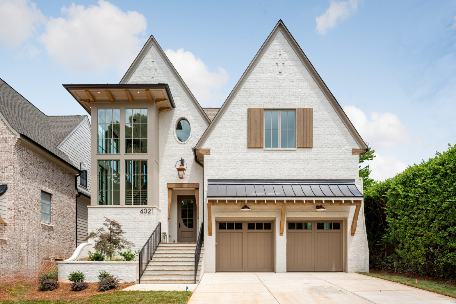 Warren plan luxury home exterior with Olympic White painted brick, wood accents, large windows, and copper gas lantern by Pike Properties in Charlotte