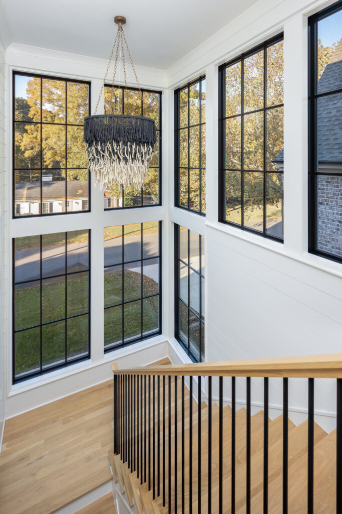 Warren plan staircase and floor-to-ceiling windows with statement chandelier